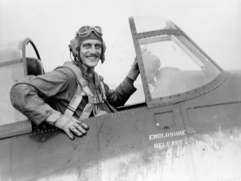 Giftos smiling from the cockpit of an FM-2 Wildcat, in helmet and goggles
