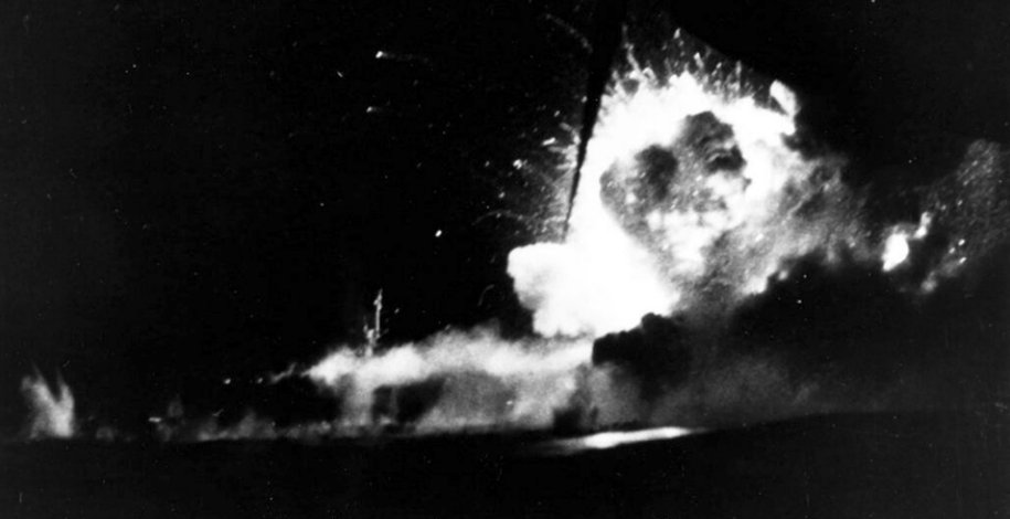 Night photograph of a large explosion on the escort carrier