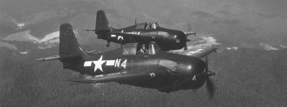 Two FM-2 Wildcats, N4 in the foreground, flying in formation over hills