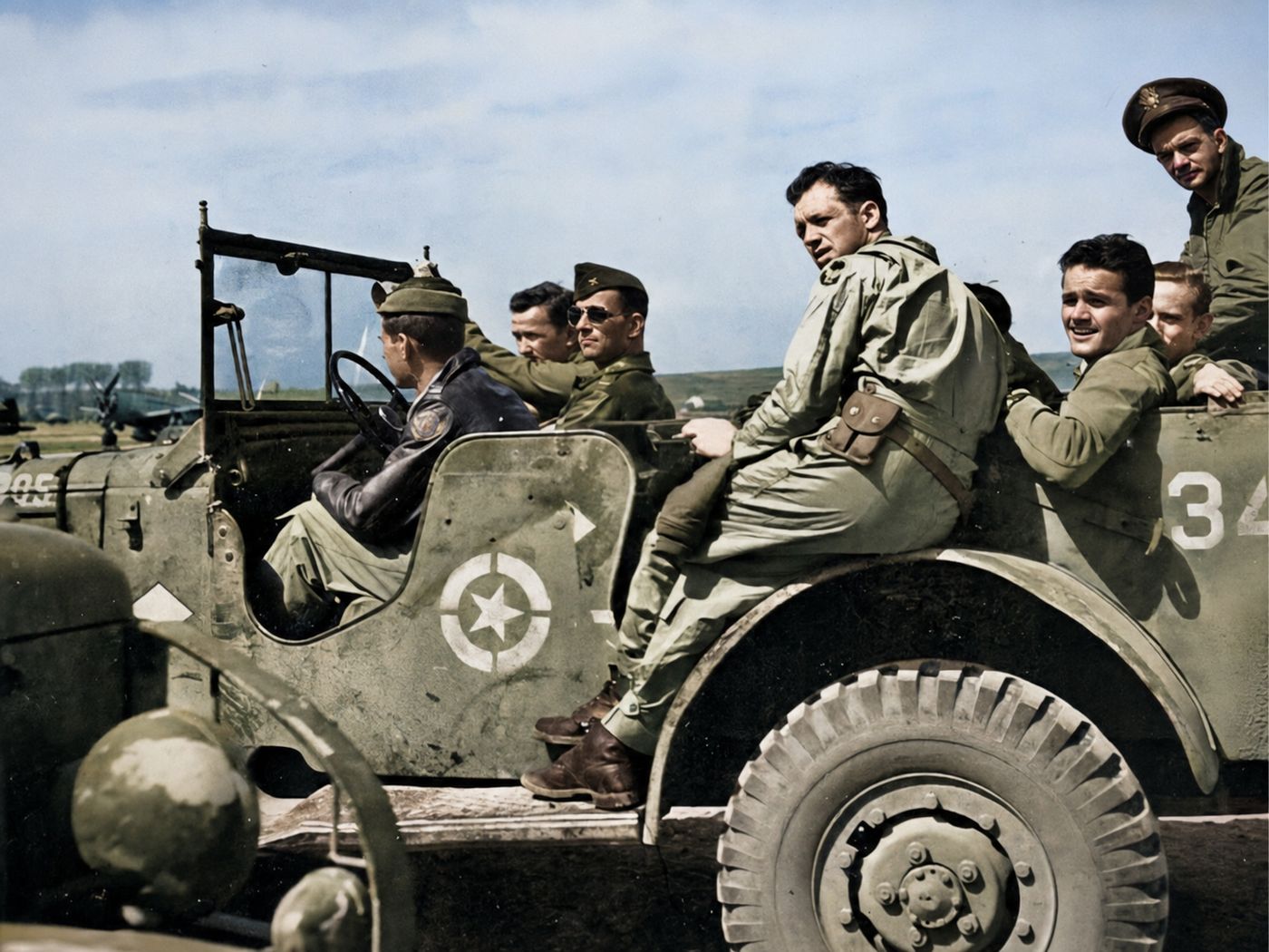 Airmen riding on a jeep