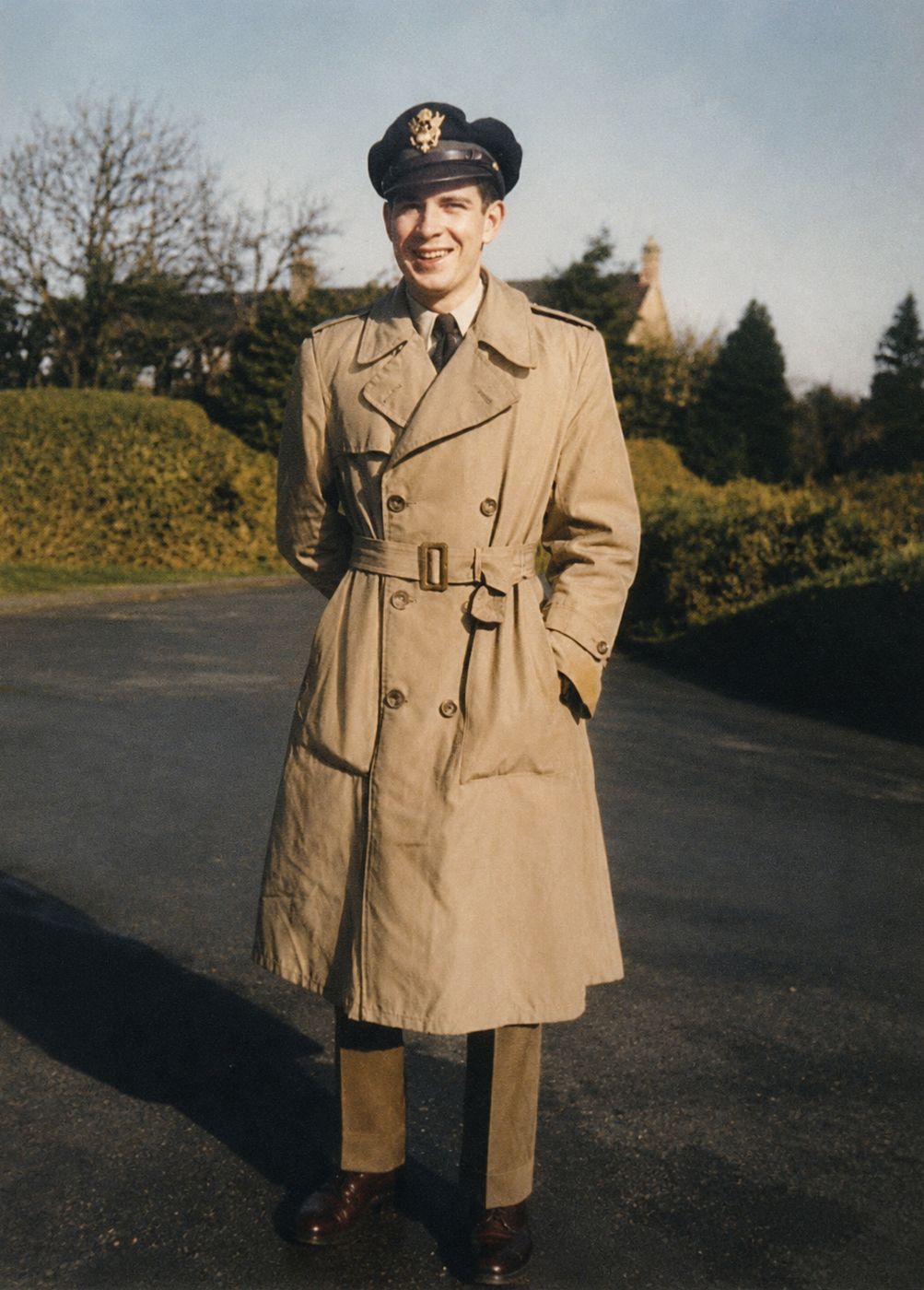 Kandis in a trench coat and officer's cap